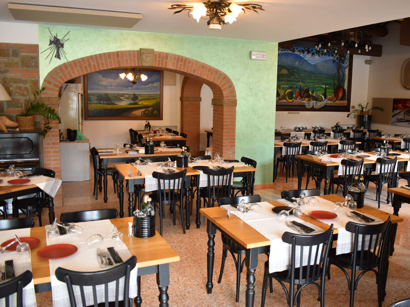 Sala con arco centrale in mattoni e tavoli apparecchiati